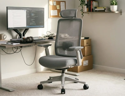 Fotel Ergonomiczny Biurowy ERGONAUT ODYSSEY Szary w domowym biurze - widok z przodu pod kątem z lewej strony.